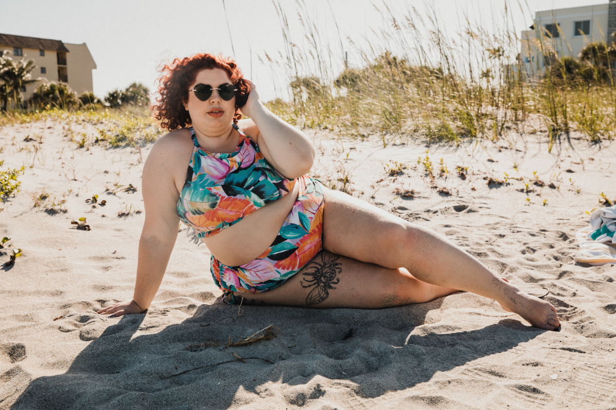 Eine Plus-size-Frau im Bikini an einem Strand.