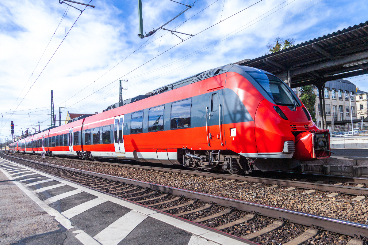 Ein Zug der Deutschen Bahn steht am Gleis an einem Bahnhof.