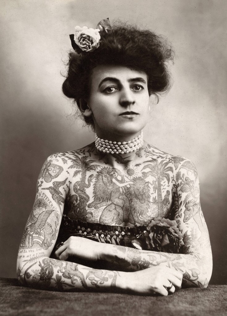 Ein Schwarz-weiß-Foto einer tätowierten Frau, einer sogenannten Tattooed Lady.